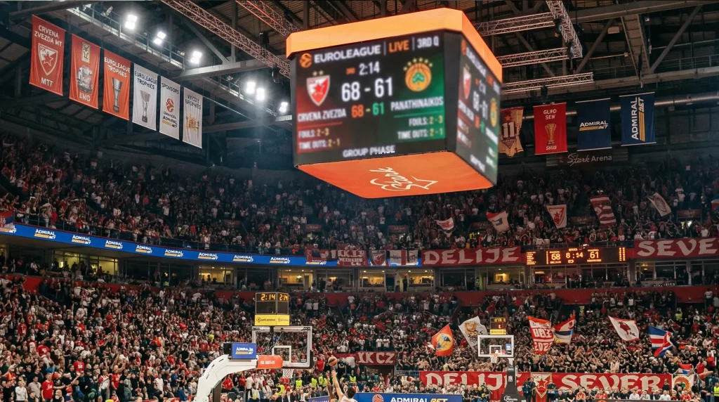 Pabellón de baloncesto europeo durante un partido de Euroliga con el marcador encendido y las gradas llenas