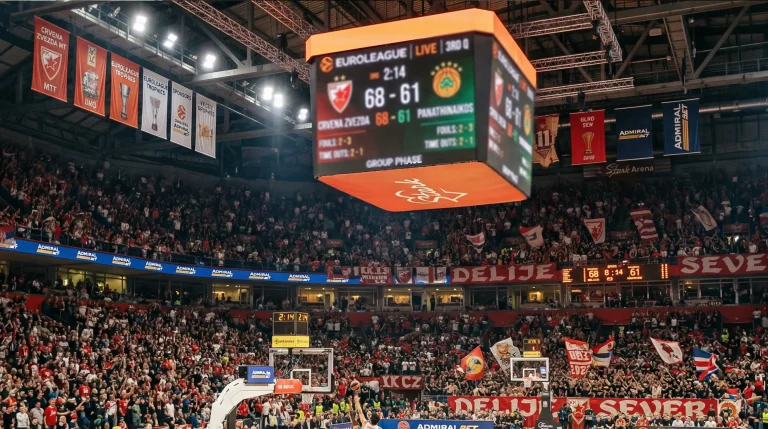 Pabellón de baloncesto europeo durante un partido de Euroliga con el marcador encendido y las gradas llenas